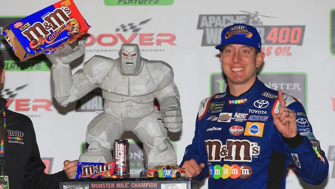 Kyle Busch shares a packet of caramel M&Ms with mascot Miles the Monster after winning the playoff race at Dover International Speedway on Oct. 1.