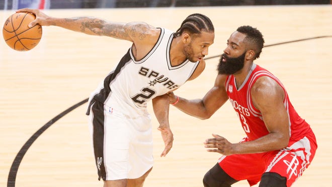 San Antonio Spurs forward Kawhi Leonard is defended by Houston Rockets guard James Harden during the second half at AT&T Center.