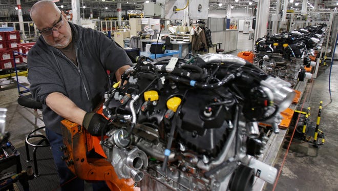 A repairman works on an engine on the assembly line at the Ford Cleveland Engine Plant 1 in Brook Park, Ohio.