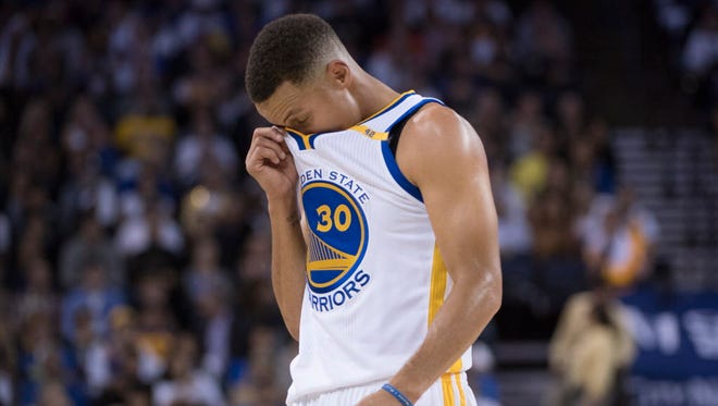 Warriors guard Stephen Curry (30) reacts during the third quarter against the Spurs.