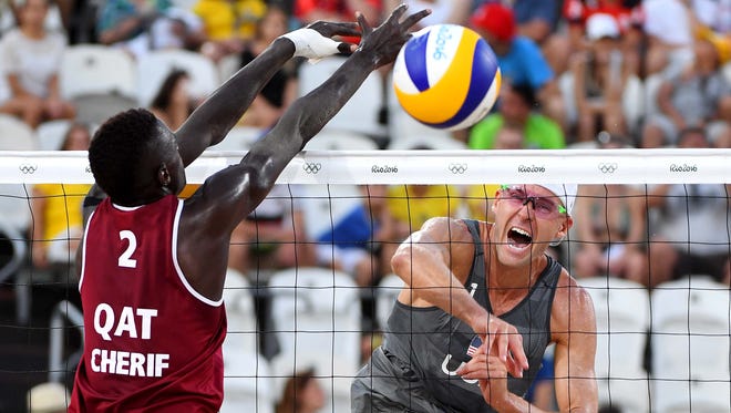 Casey Patterson (USA) hits the ball against Cherif Younousse Samba (QAT) during the men's beach volleyball preliminary round in the Rio 2016 Summer Olympic Games at Beach Volleyball Arena.