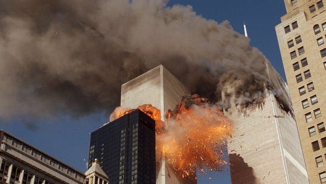 Smoke billows from one of the towers of the World Trade Center and flames and debris explode from the second tower.