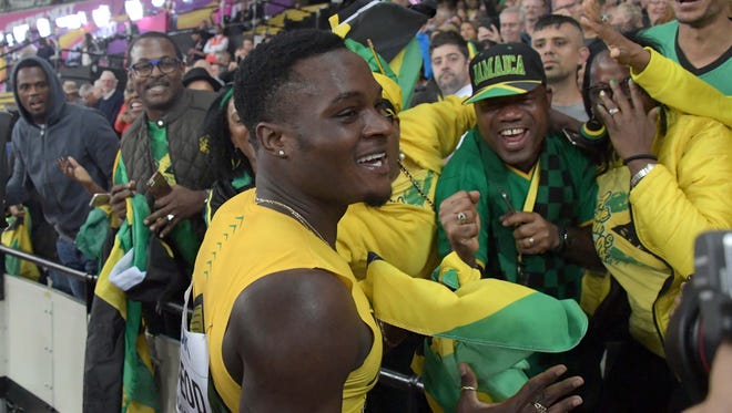 Omar McLeod celebrates with Jamaican fans after winning the 110 hurdles.
