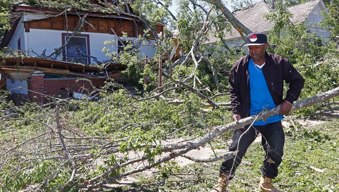 Dee Andre Johnson, 48, hauls off branches Monday, May 1, 2017, that fell on his neighbor's house Sunday morning, during a possible tornado that swept through Durant, Miss.