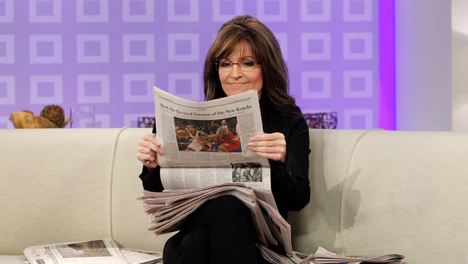 Palin holds a newspaper as she co-hosts NBC's "Today" show in New York on April 3, 2012.