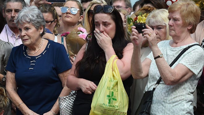 People stop to observe a minute's silence in St Ann's Square in Manchester, England, as a mark of respect to the victims of the May 22 terrorist attack.