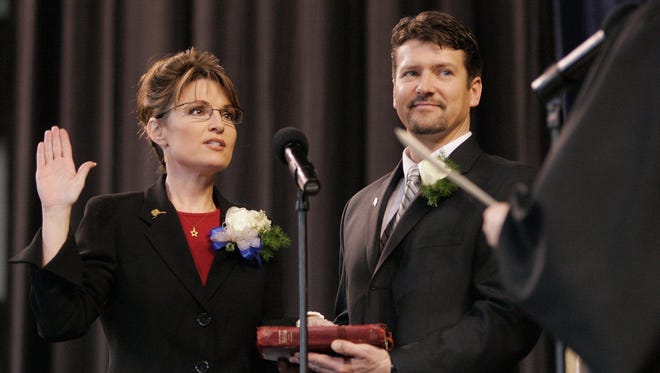 Palin is sworn in as governor of Alaska as her husband, Todd Palin, holds the Bible during an inauguration ceremony in Fairbanks, Alaska, on Dec. 4, 2006.
