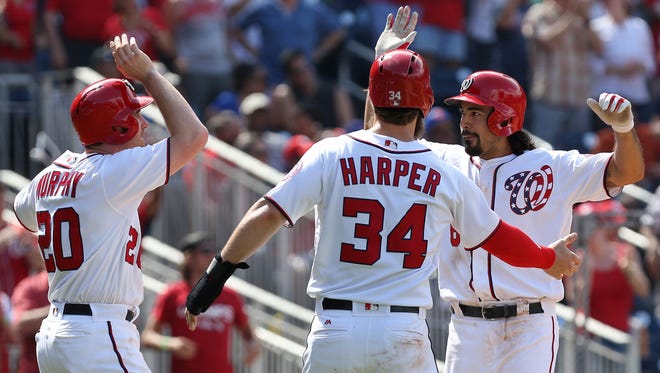 The Washington Nationals'n Anthony Rendon (right) celebrates with Daniel Murphy (20) and Bryce Harper (34) after hitting a three-run home run against the New York Mets.