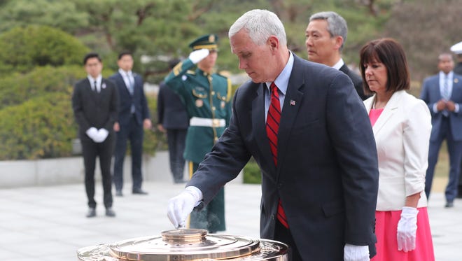 U.S. Vice President Mike Pence burns incense in front of his wife Karen Pence, right, at the Seoul National Cemetery in Seoul, South Korea, Sunday, April 16, 2017.