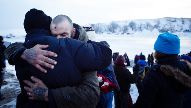 Demonstrators embrace after a daily water ceremony in the Oceti Sakowin Camp near the Standing Rock Reservation on Saturday, Dec. 3, 2016 near Cannon Ball.