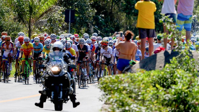 The main peleton passes through Prainha during the men's road race in the Rio 2016 Summer Olympic Games at Fort Copacabana.