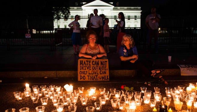 People gather in front of the White House on August 13, 2017 in Washington, D.C. for a vigil in response to the death of a counter-protestor in the August 12th "Unite the Right" rally the turned violent in Charlottesville, Va. Two state police officers died in a helicopter crash near the area.