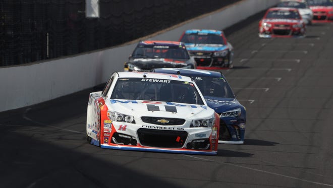 Stewart leads a group of cars into Turn 1 during his final Sprint Cup race at Indianapolis Motor Speedway.