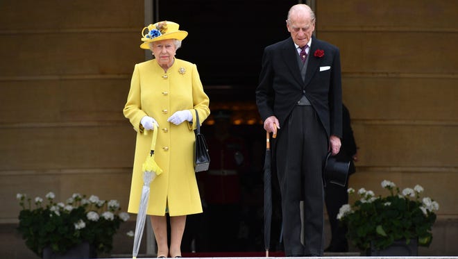 Britain's Queen Elizabeth and Prince Philip observe a minute's silence at the start of a garden party at Buckingham Palace in London on May 23, 2017. The Islamic State group claimed responsibility Tuesday for the suicide attack at an Ariana Grande show that left 22 people dead and dozens injured.