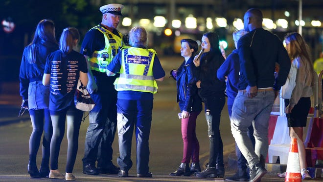 Police and fans close are pictured outside Manchester Arena after at least 19 people were killed following an explosion at the end of an Ariana Grande concert in Manchester, England.