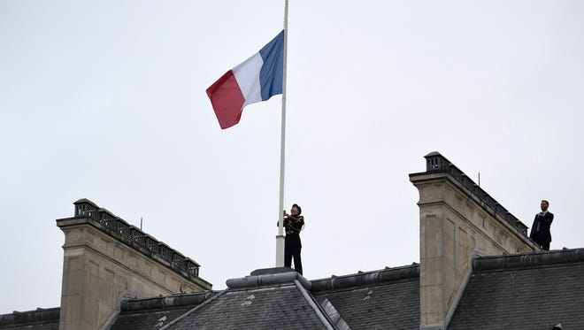 A Republican Guard flies the French flag at half mast at the Elysee presidential Palace in Paris, in tribute to the victims of the terror attack at the Ariana Grande concert in Manchester May 24, 2017.