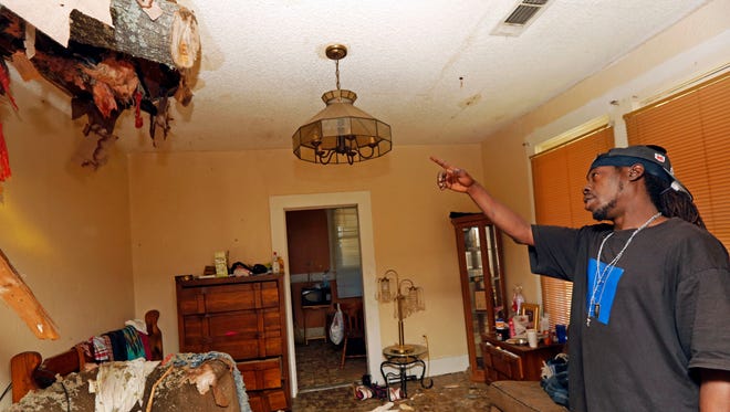 Walter Coleman points at the remainder of a tree limb on May 1, 2017, that crashed into his house the day before during a possible tornado in Durant, Miss. Coleman and his family had taken shelter in the living room Sunday when the limb crashed through the roof.