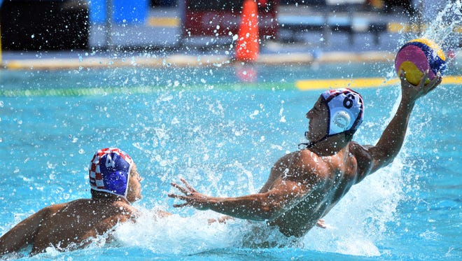 Luca Cupido of the United States holds the ball against Luka Loncar of Croatia during a men's preliminary round water polo match in the Rio 2016 Summer Olympic Games at Maria Lenk Aquatics Centre.