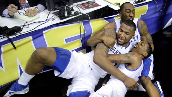 2010: Kentucky's DeMarcus Cousins, center, celebrates with Ramon Harris, top, and Darnell Dodson, bottom, after Cousins scored at the buzzer.