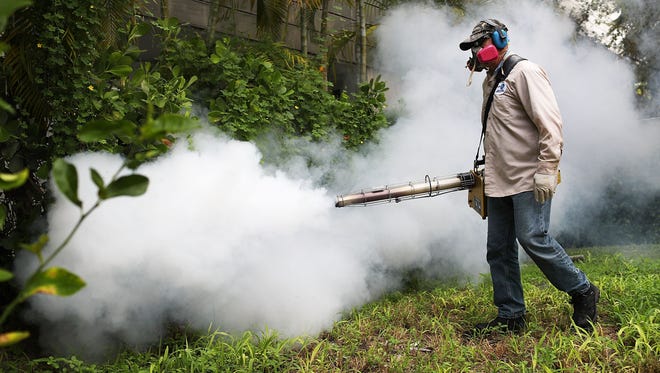 Carlos Varas, a Miami-Dade County mosquito control inspector, uses a Golden Eagle blower to spray pesticide to kill mosquitos in the Miami Beach neighborhood as the county fights to control the Zika virus outbreak on August 24, 2016 in Miami Beach, Fla.