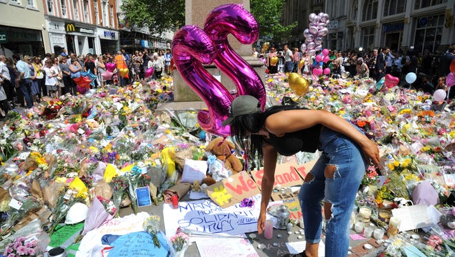 A young woman views of flower tributes  for the victims of Monday's explosion at St Ann's square in central Manchester, England May 25 2017.