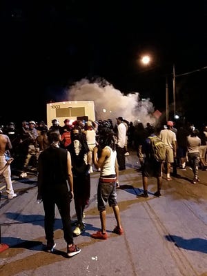 Police fire tear gas into the crowd of protesters on Old Concord Road late Tuesday night in Charlotte, N.C.