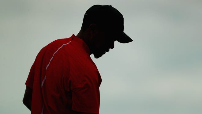 Woods looks on from the practice range during the final round.