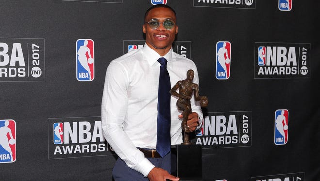 Westbrook poses for photos with his 2017 NBA most valuable player award.