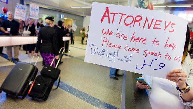 Volunteer lawyers hold signs offering help to people at Los Angeles International Airport following President Trump's executive order banning citizens from seven predominantly Muslim countries from entering the U.S.