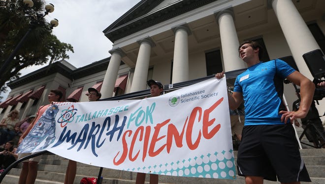 Greg Short, right, joins thousands of people gathering together at the Historic Capitol building downtown Tallahassee, Fla. for the March for Science.