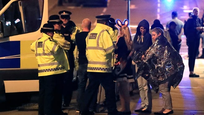 Emergency services personnel speak to people outside Manchester Arena after reports of an explosion at the venue during an Ariana Grande concert in Manchester, England, Monday, May 22, 2017. Several people have died following an explosion Monday night at an Ariana Grande concert in northern England, police and witnesses said. The singer was not injured, according to a representative. (Peter Byrne/PA via AP) ORG XMIT: TKMY810