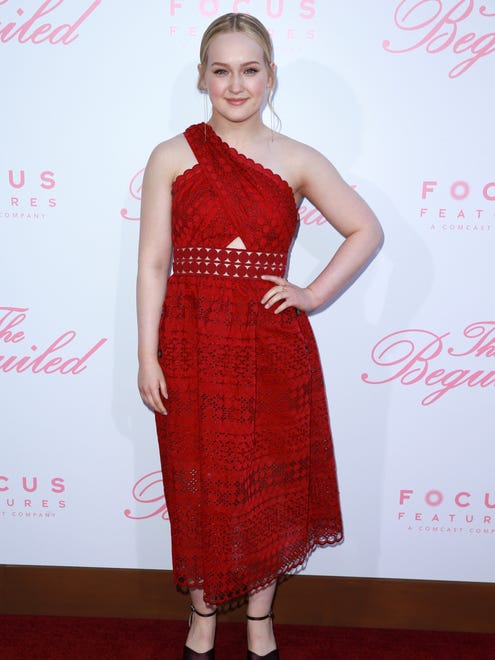 Actor Emma Howard wore an asymmetrical, one-shouldered red dress to the premiere.