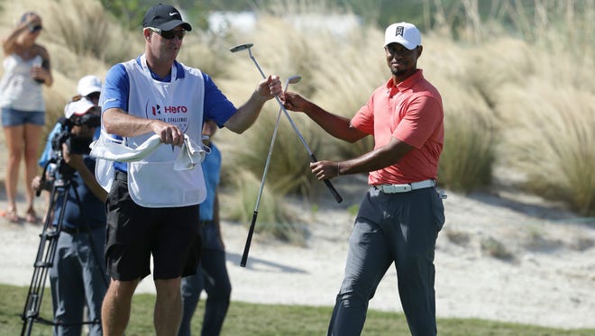 Tiger Woods exchanges clubs with his caddie Joe LaCava on the 16th hole during the Pro-Am at the Hero World Challenge.