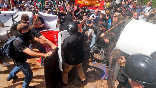 White nationalist demonstrators clash with counter demonstrators at the entrance to Lee Park in Charlottesville, Va., Saturday, Aug. 12, 2017. Gov. Terry McAuliffe declared a state of emergency and police dressed in riot gear ordered people to disperse after chaotic violent clashes between white nationalists and counter protestors. (AP Photo/Steve Helber)