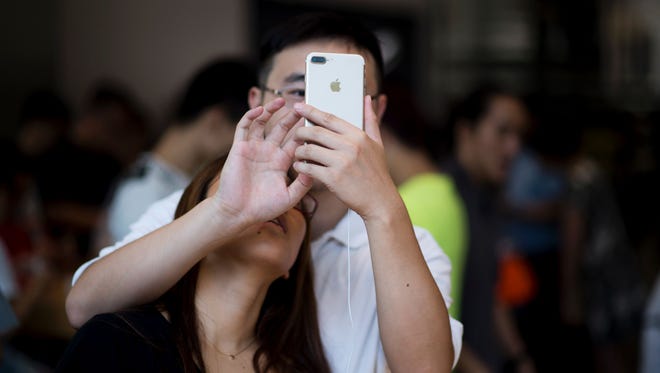 A Chinese couple tests the new iPhone 7 during the opening sale launch at an Apple store in Shanghai on Sept. 16, 2016. With new iPhones hitting the markets on Sept. 16, Apple is seeking to regain momentum and set new trends for the smartphone industry and tech sector.