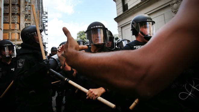Protesters face off with riot police following a march in Boston against a planned "Free Speech" rally.