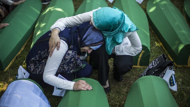 Women mourn over the coffin before the mass funeral for 136 newly-identified victims of the 1995 Srebrenica massacre attended by tens of thousands of mourners during the 20th anniversary of the massacre at the Potocari cemetery and memorial on July 11, 2015 in Srebrenica, Bosnia and Herzegovina.