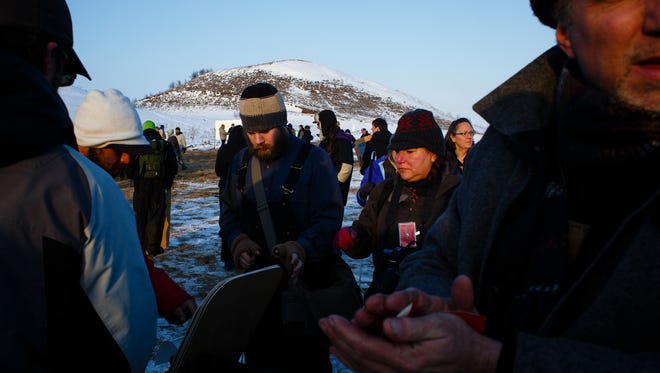 Demonstrators pick up mirrors as they prepare to practice an art demonstration intended to reflect the police officers aggression back to them according to native artist Rory Erler Wakemup in the Oceti Sakowin Camp near the Standing Rock Reservation on Saturday, Dec. 3, 2016 near Cannon Ball.