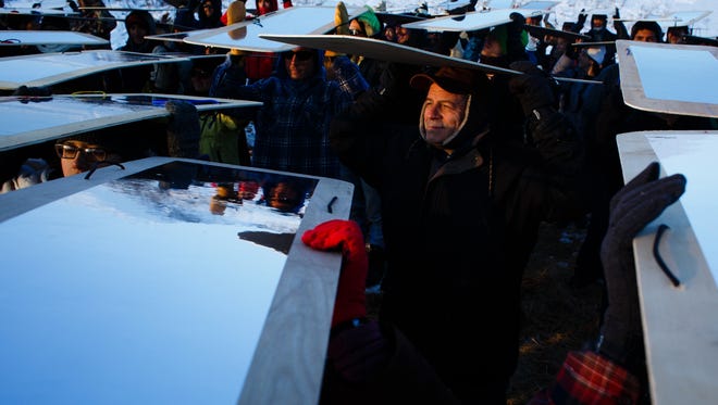 Michael Hopkins, 59 of Neenah, WI, holds a mirror and he and other demonstrators prepare to practice an art demonstration intended to reflect the police officers aggression back to them according to native artist Rory Erler Wakemup in the Oceti Sakowin Camp near the Standing Rock Reservation on Saturday, Dec. 3, 2016 near Cannon Ball.
