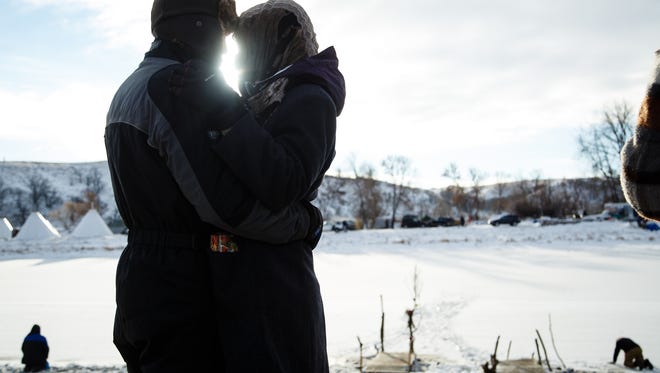 Ariel Wolansky, left, and Ashley Seday, right, both of Auburn, CA, embrace as they gather at the Cannonball River during the morning prayer in the Oceti Sakowin Camp near the Standing Rock Reservation on Sunday, Dec. 4, 2016 in Cannon Ball.