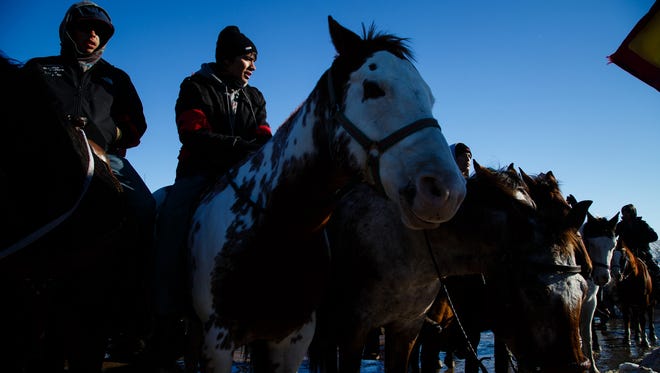 Riders on horseback gather as people speak during an interfaith prayer circle in the Oceti Sakowin Camp near the Standing Rock Reservation on Sunday, Dec. 4, 2016 near Cannon Ball.