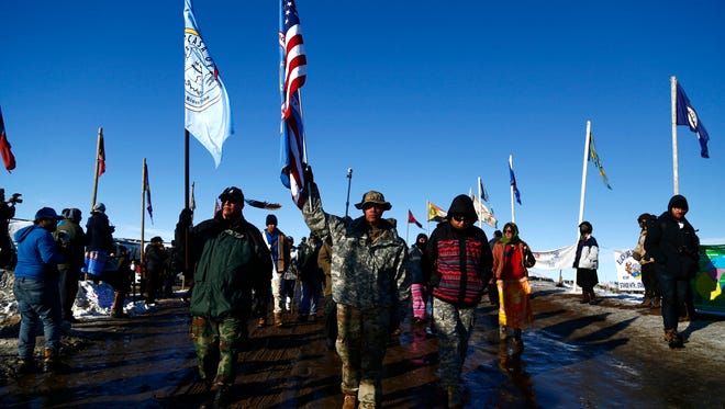 Veterans walk down flag row in the Oceti Sakowin Camp near the Standing Rock Reservation on Sunday, Dec. 4, 2016 near Cannon Ball.