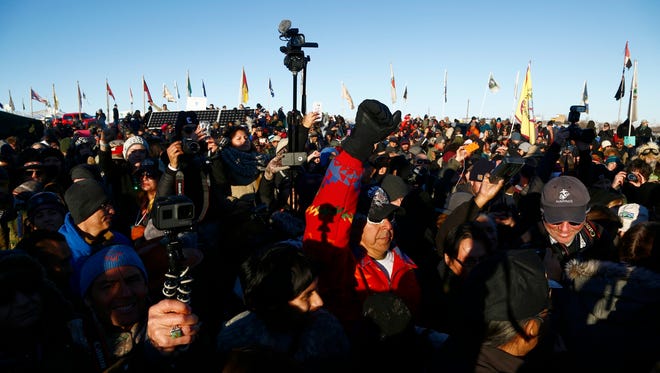 Demonstrators chant around the drum circle at the Oceti Sakowin Camp after the Army Corps of Engineers denied Dakota Access an easement to cross the Missouri River on Sunday, Dec. 4, 2016 near Cannon Ball.