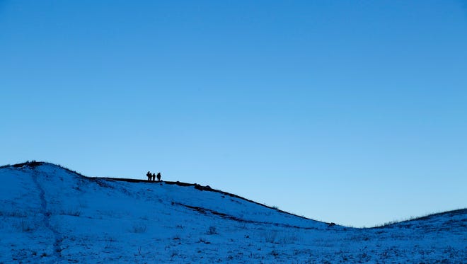 Demonstrators walk the hills above the Oceti Sakowin Camp near the Standing Rock Reservation on Sunday, Dec. 4, 2016 near Cannon Ball.