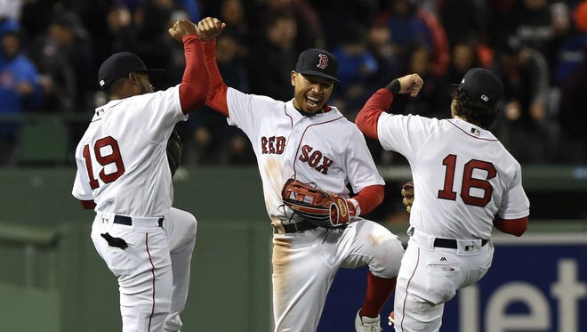 Boston Red Sox outfielders 
 Jackie Bradley Jr. (19), Mookie Betts (center) and Andrew Benintendi (16) react after defeating the Chicago Cubs.