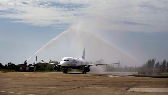 Firetrucks spray water over JetBlue flight 387, "baptizing" the first commercial flight between the US and Cuba in more than half a century, after touching down at the airport in Santa Clara, Cuba.