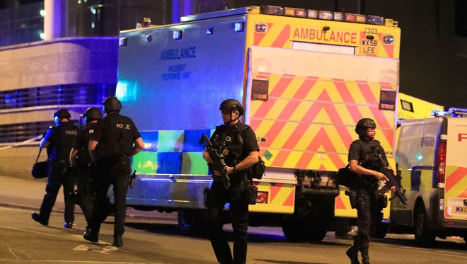 Armed police work at Manchester Arena after reports of an explosion at the venue during an Ariana Grande concert.