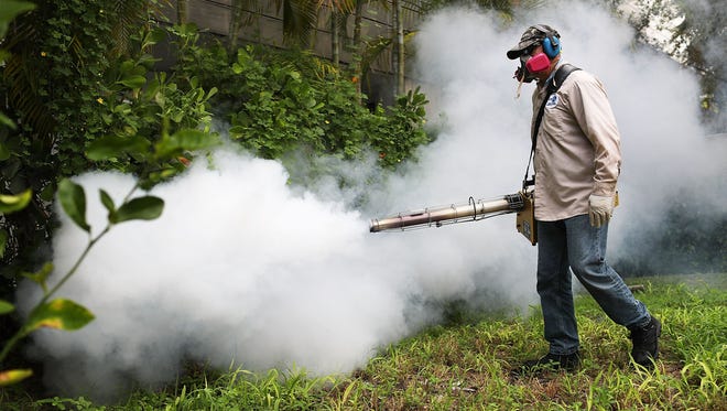 Carlos Varas, a Miami-Dade County mosquito control inspector, sprays pesticide to kill mosquitos in the Miami Beach neighborhood on Aug. 24, 2016, as the county fights to control a Zika virus outbreak.