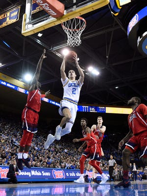 Lonzo Ball of the UCLA Bruins scores a basket against Kadeem Allen of the Arizona Wildcats during the first half of the game at Pauley Pavilion.