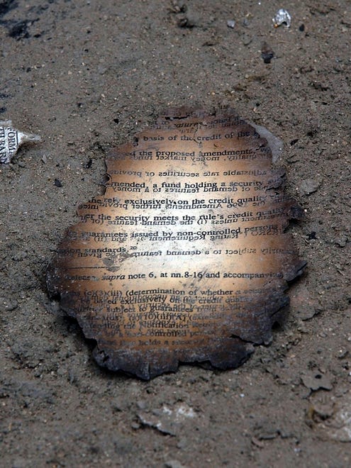 A charred document sits in the soot near the destroyed World Trade Center.